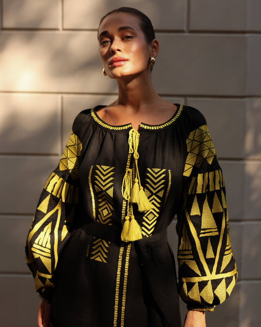 Black linen kaftan maxi dress with gold geometric embroidery, balloon sleeves and gold tassel ties, editorial view - Zalxndra Resort