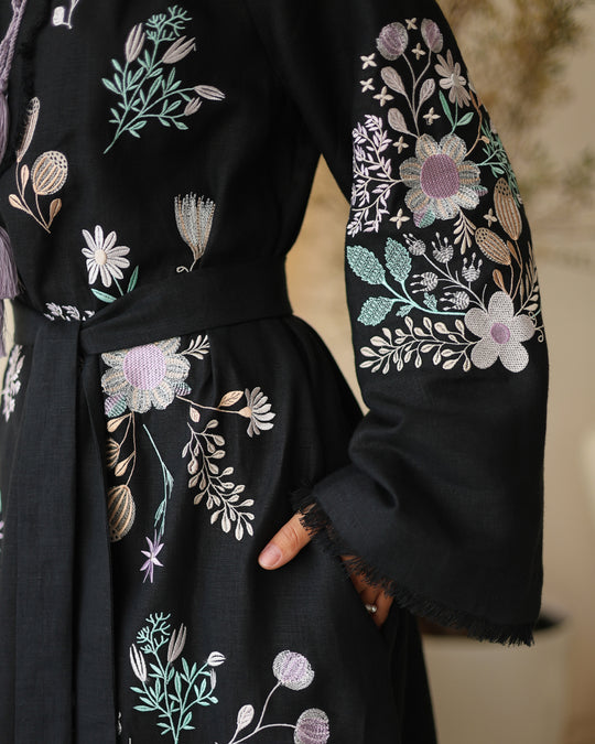 Close-up of pastel floral embroidery and frayed bell sleeve on black linen kaftan maxi dress - Zalxndra Resort