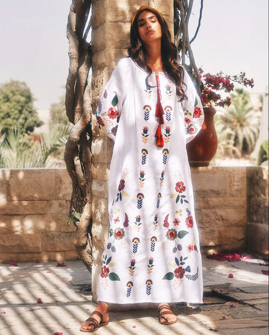White linen kaftan maxi dress with multicolour folk floral embroidery, balloon sleeves, and tassel ties, full-length view - Zalxndra Resort