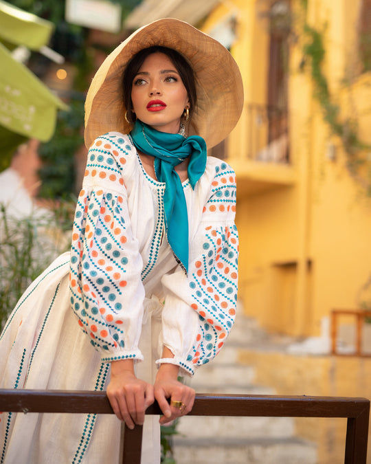 White linen maxi dress with teal and orange geometric embroidery, balloon sleeves, styled with straw hat and teal silk scarf - Zalxndra Resort