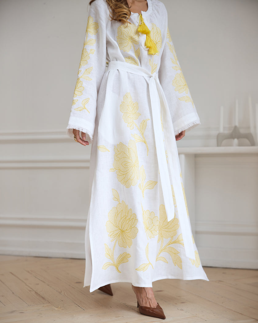 Full-length view of white linen kaftan maxi dress with yellow floral embroidery, frayed angel sleeves, and tassel tie - Zalxndra Resort