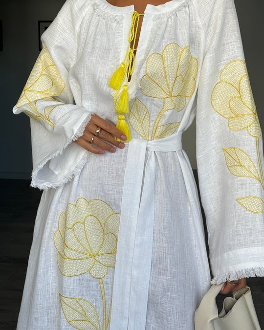 Bodice detail of white linen kaftan maxi dress with yellow outlined floral embroidery, frayed angel sleeves, and tassel tie - Zalxndra Resort